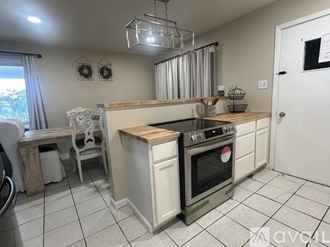 A kitchen with a white oven and a wooden counter.