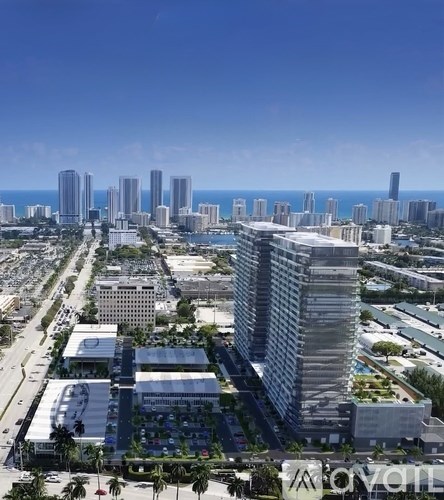 A cityscape with tall buildings and palm trees.