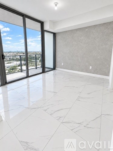 A spacious room with marble flooring and a view of the city through large windows.