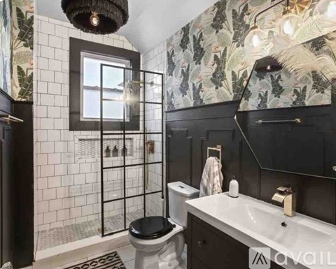 A bathroom with a black and white tiled shower area.