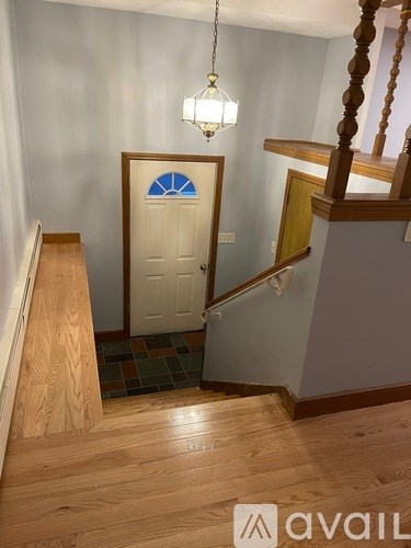 A wooden staircase with a light hanging from the ceiling.