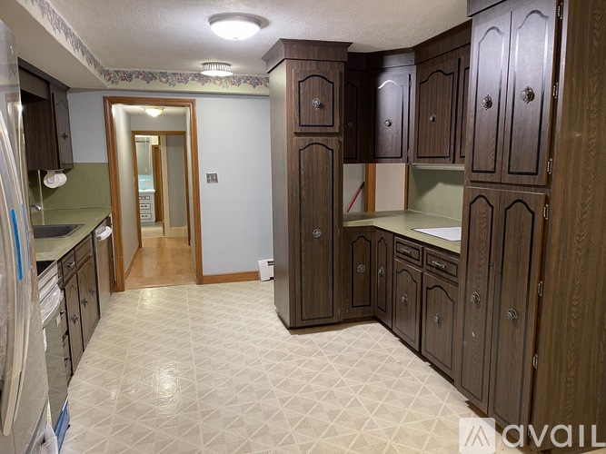 A kitchen with wooden cabinets and a tiled floor.