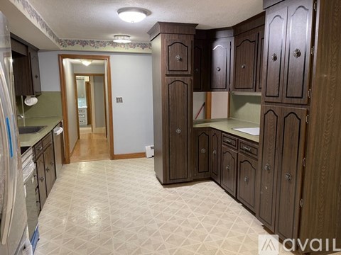 A kitchen with wooden cabinets and a tiled floor.