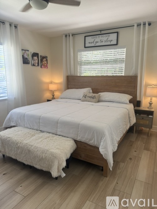 A bedroom with a large bed and a sign above it that says "Give it to God and let's sleep".