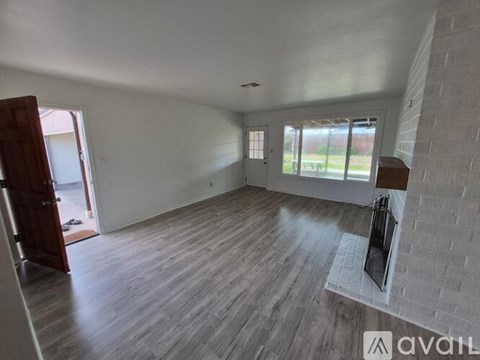 A room with wooden flooring and a fireplace is available for rent.