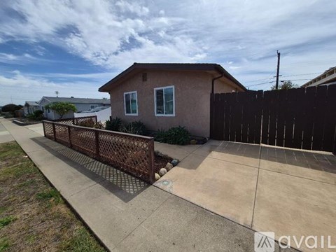A house with a brown fence and a sidewalk in front.