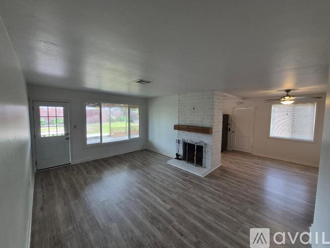 A spacious room with a fireplace and sliding glass doors.