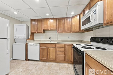 A kitchen with wooden cabinets and white appliances.