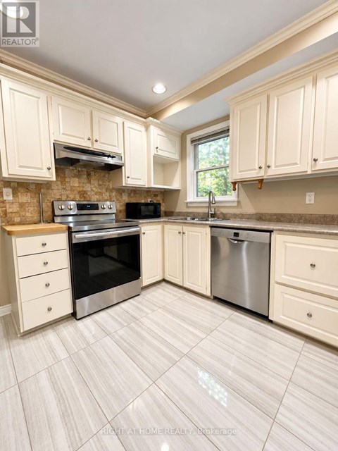 A kitchen with white cabinets and a tile floor.