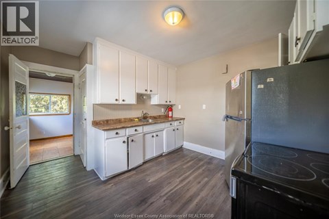 A kitchen with white cabinets and a black stove top oven.