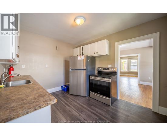 A kitchen with a refrigerator, oven, and sink.