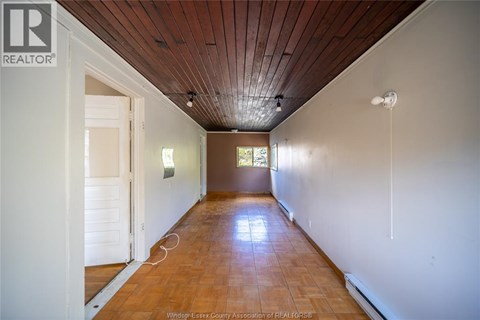 A long hallway with a wooden ceiling and floor.