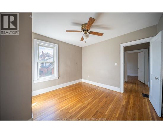 A room with a ceiling fan and a window.