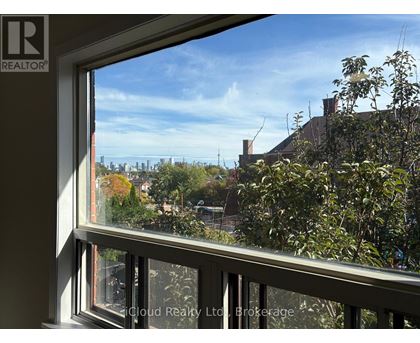 A window with a view of a cityscape and trees.