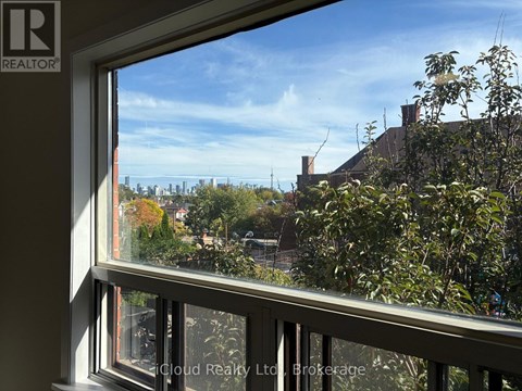 A window with a view of a cityscape and trees.