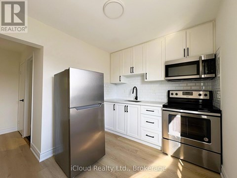 A kitchen with a stainless steel refrigerator, oven, and microwave.