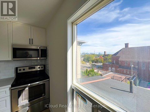 A kitchen with a stove and oven is shown through a window.