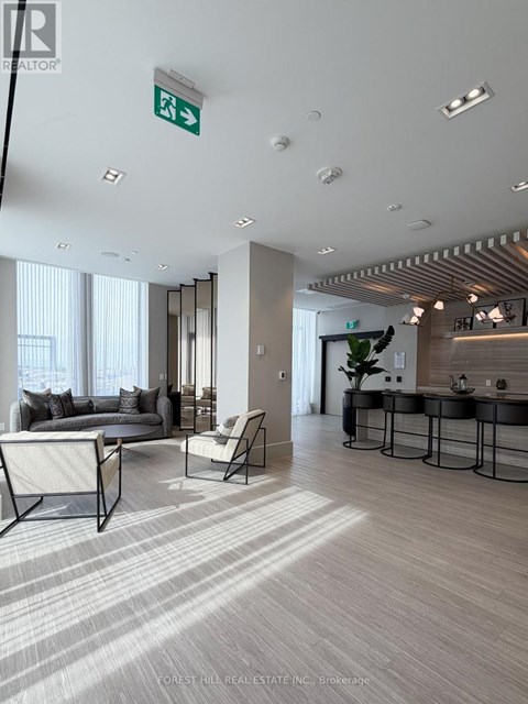 A living room with a couch, chairs, and a dining table.