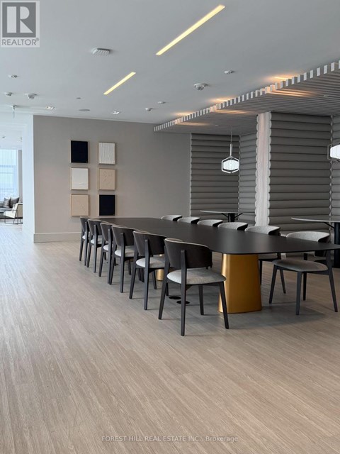 A modern dining room with a long table and chairs.