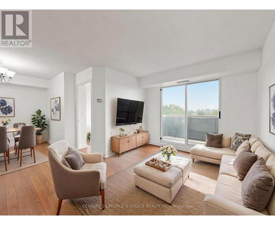 A living room with a couch, chairs, and a television.