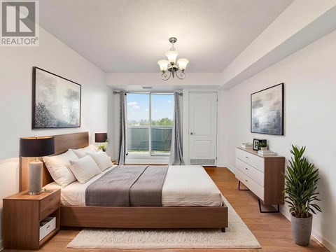 A bedroom with a large bed, a nightstand, and a plant.