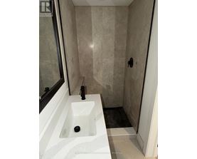 A bathroom with a sink and a shower.