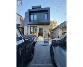 Two trucks are parked in front of a modern house.