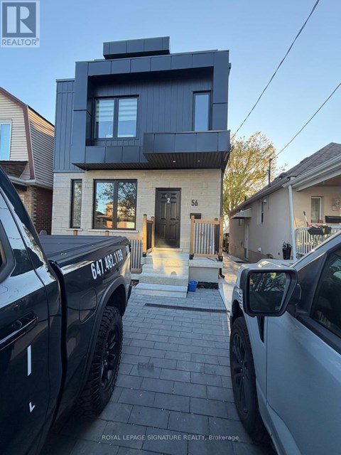 Two trucks are parked in front of a modern house.