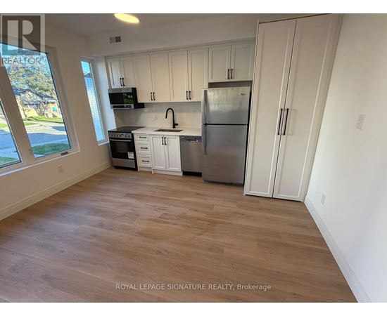 A kitchen with white cabinets and a stainless steel refrigerator.