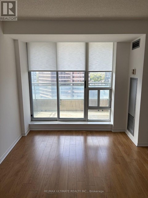 A room with a large window and wooden flooring.