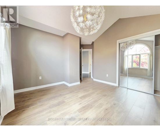 A room with a chandelier and a doorway leading to another room.
