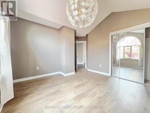A room with a chandelier and a doorway leading to another room.