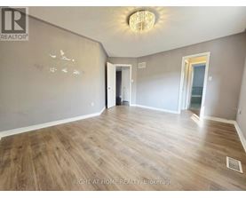 A room with wood flooring and a chandelier.