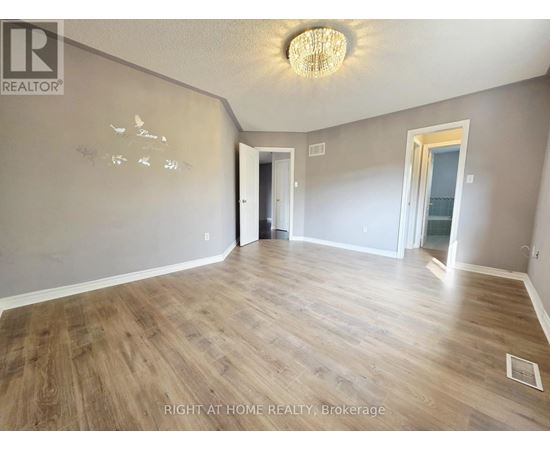 A room with wood flooring and a chandelier.