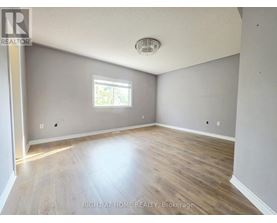 A room with a window and wooden flooring.