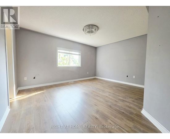 A room with a window and wooden flooring.