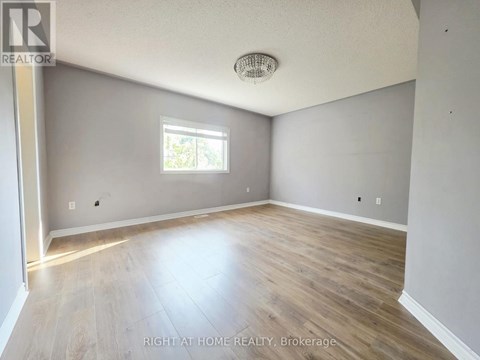 A room with a window and wooden flooring.