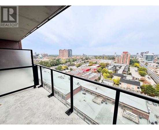 A balcony with a glass railing overlooks a cityscape.