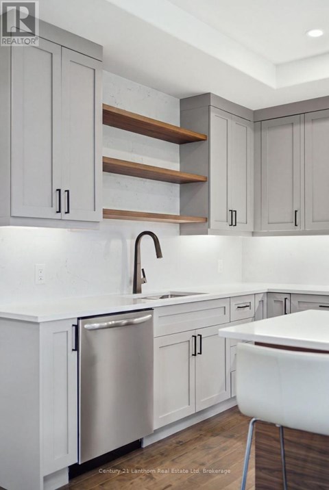 A kitchen with white cabinets and a stainless steel dishwasher.