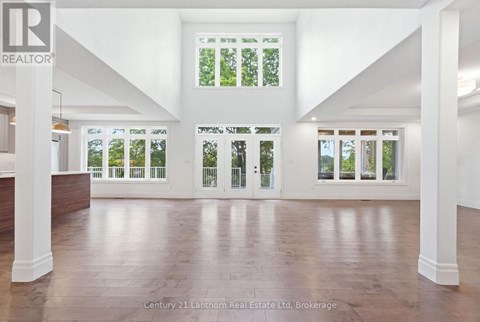 A spacious room with wooden floors and white walls.