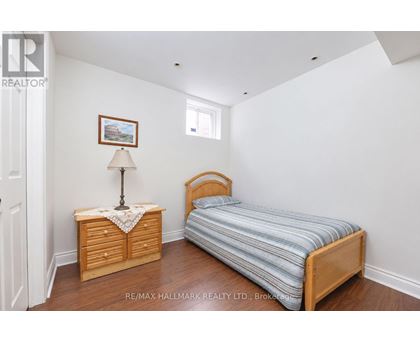 A bedroom with a bed, nightstand, and lamp.