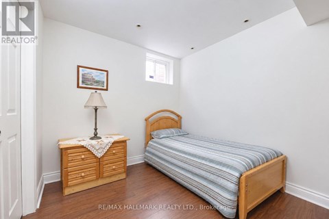 A bedroom with a bed, nightstand, and lamp.