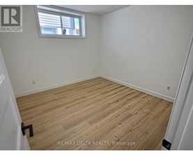 A room with wooden flooring and a window.