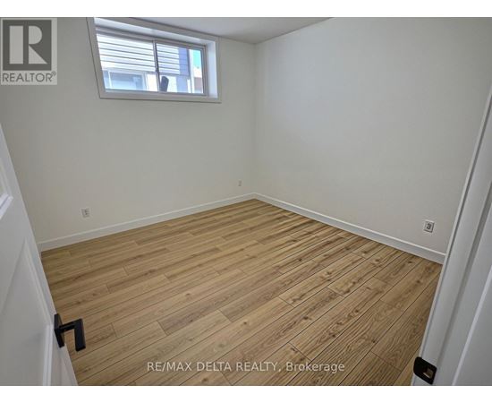 A room with wooden flooring and a window.