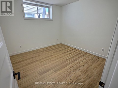 A room with wooden flooring and a window.