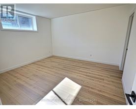 A room with wooden flooring and a window.