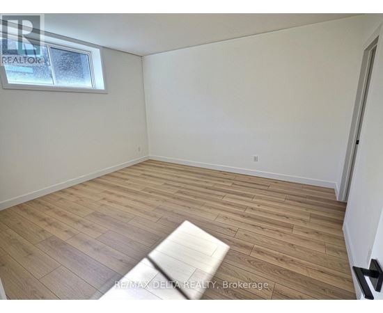 A room with wooden flooring and a window.