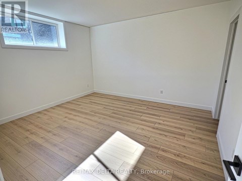 A room with wooden flooring and a window.