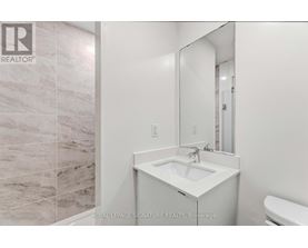 A white sink in a bathroom with a mirror above it.