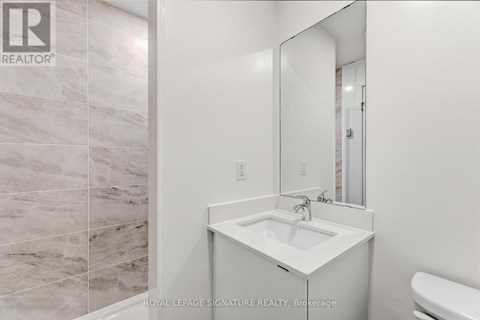 A white sink in a bathroom with a mirror above it.